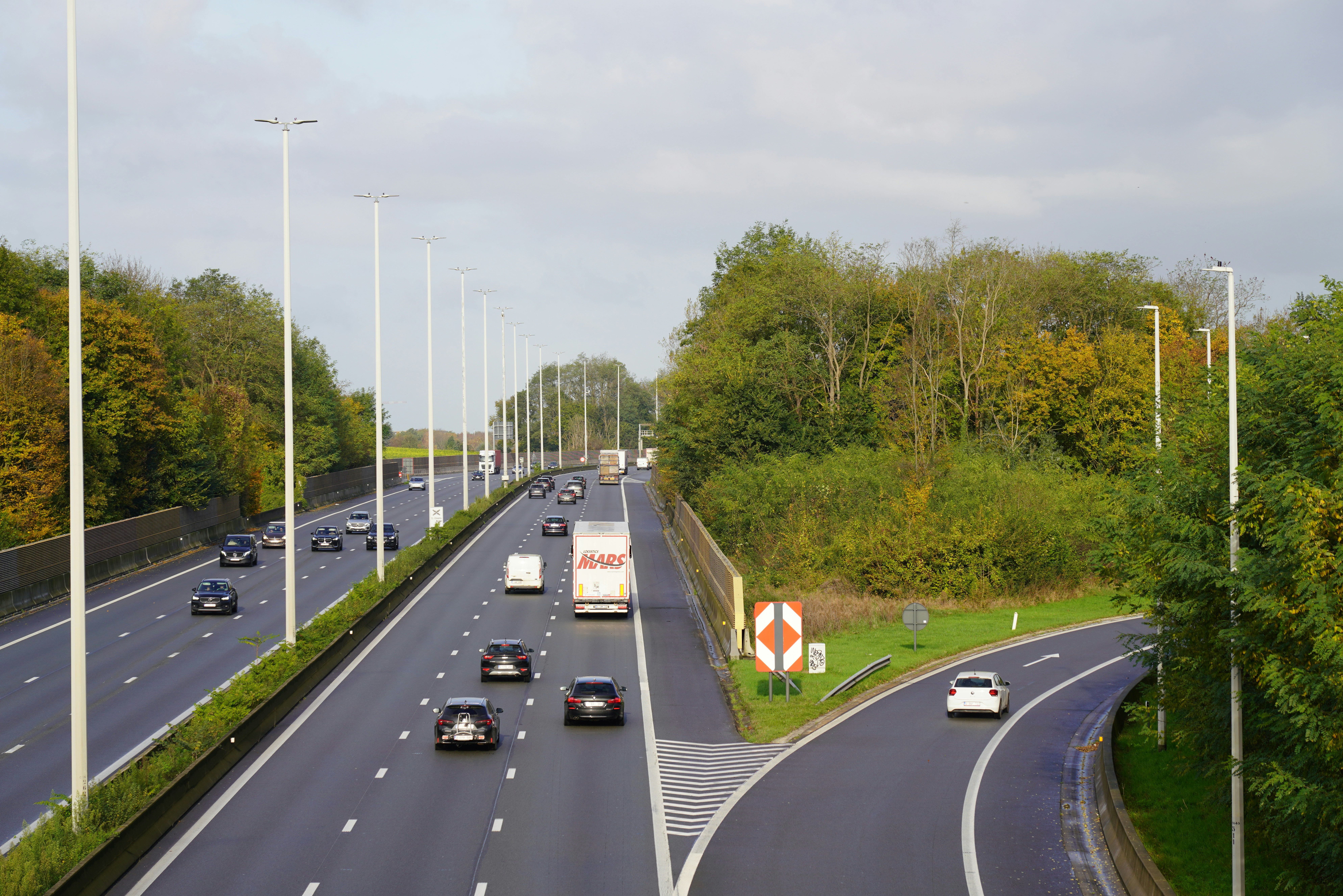 A highway with a bunch of cars driving down it