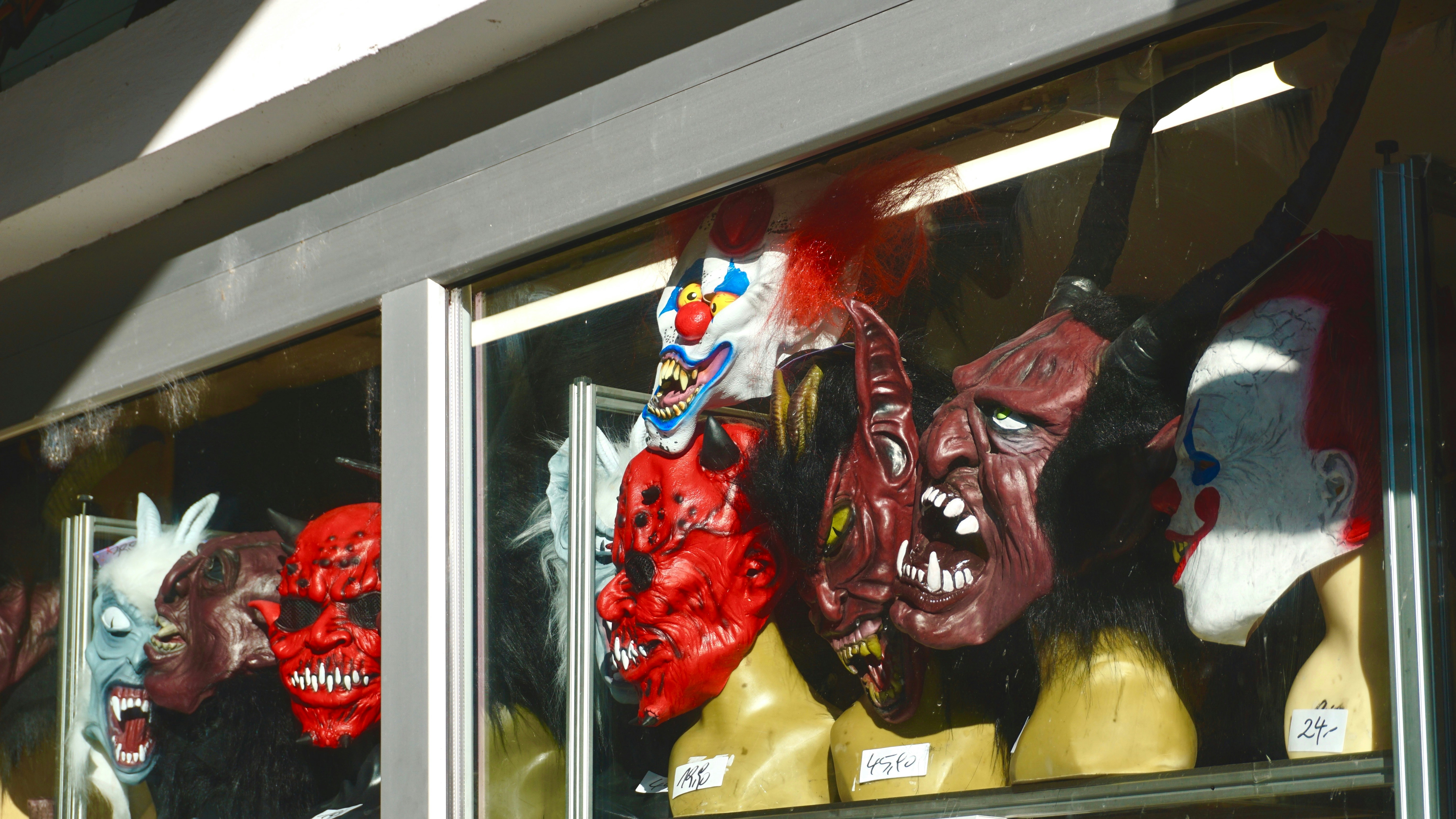 A store window with a variety of masks on display