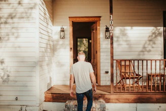 A man standing on the porch of a house