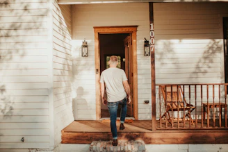 A man standing on the front porch of a house
