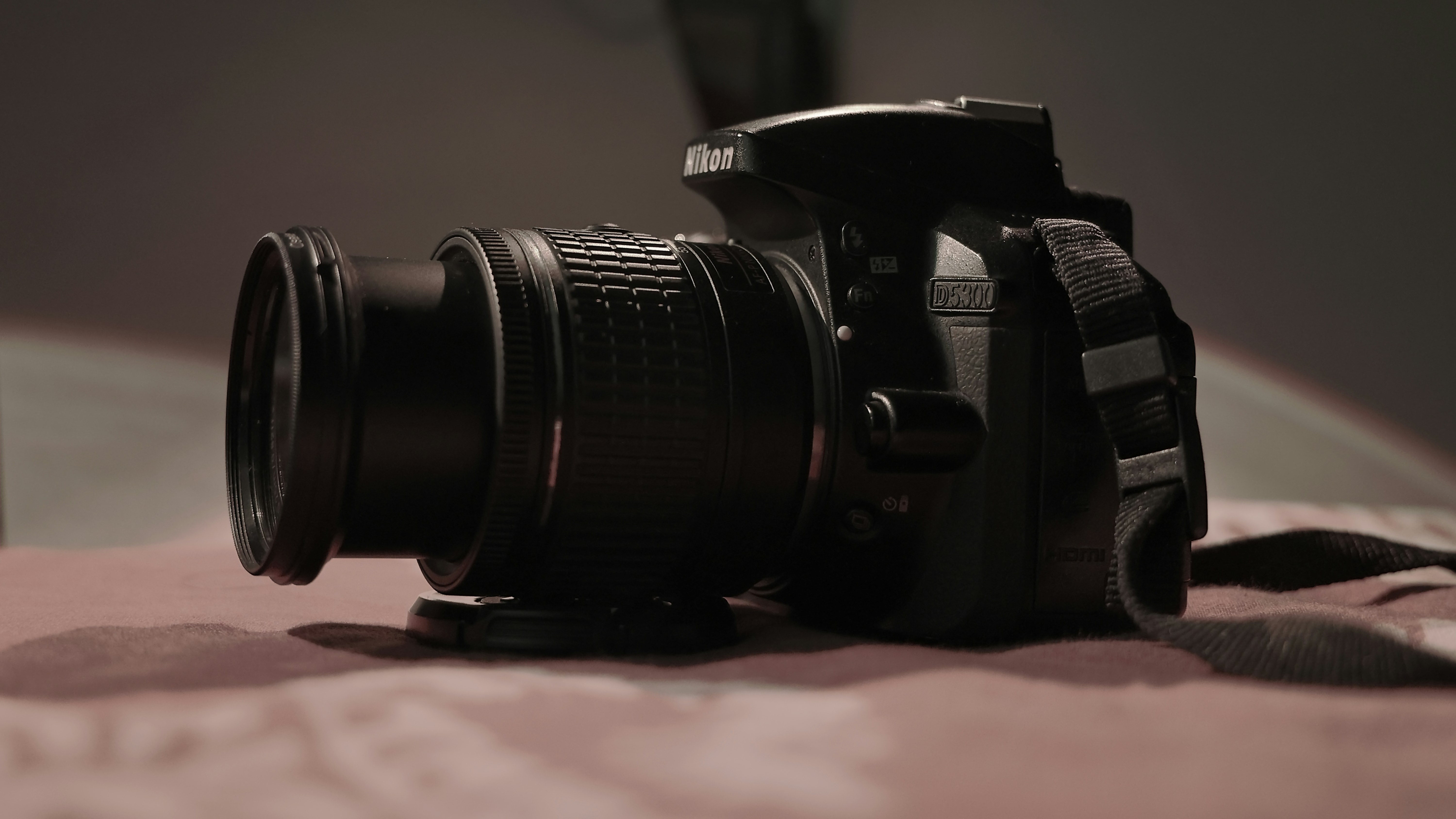 A camera sitting on top of a bed next to a pillow