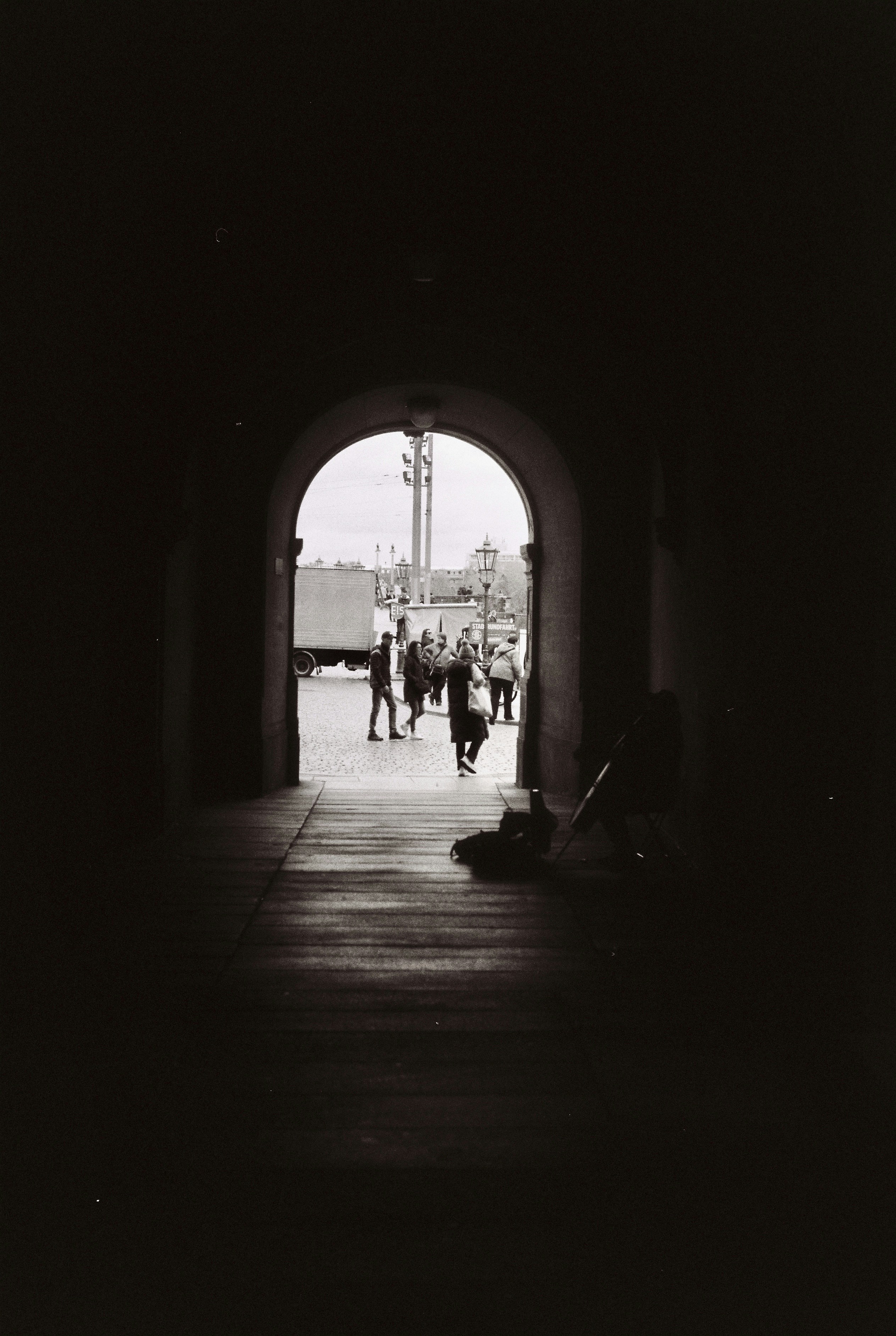 A black and white photo of people walking through a tunnel