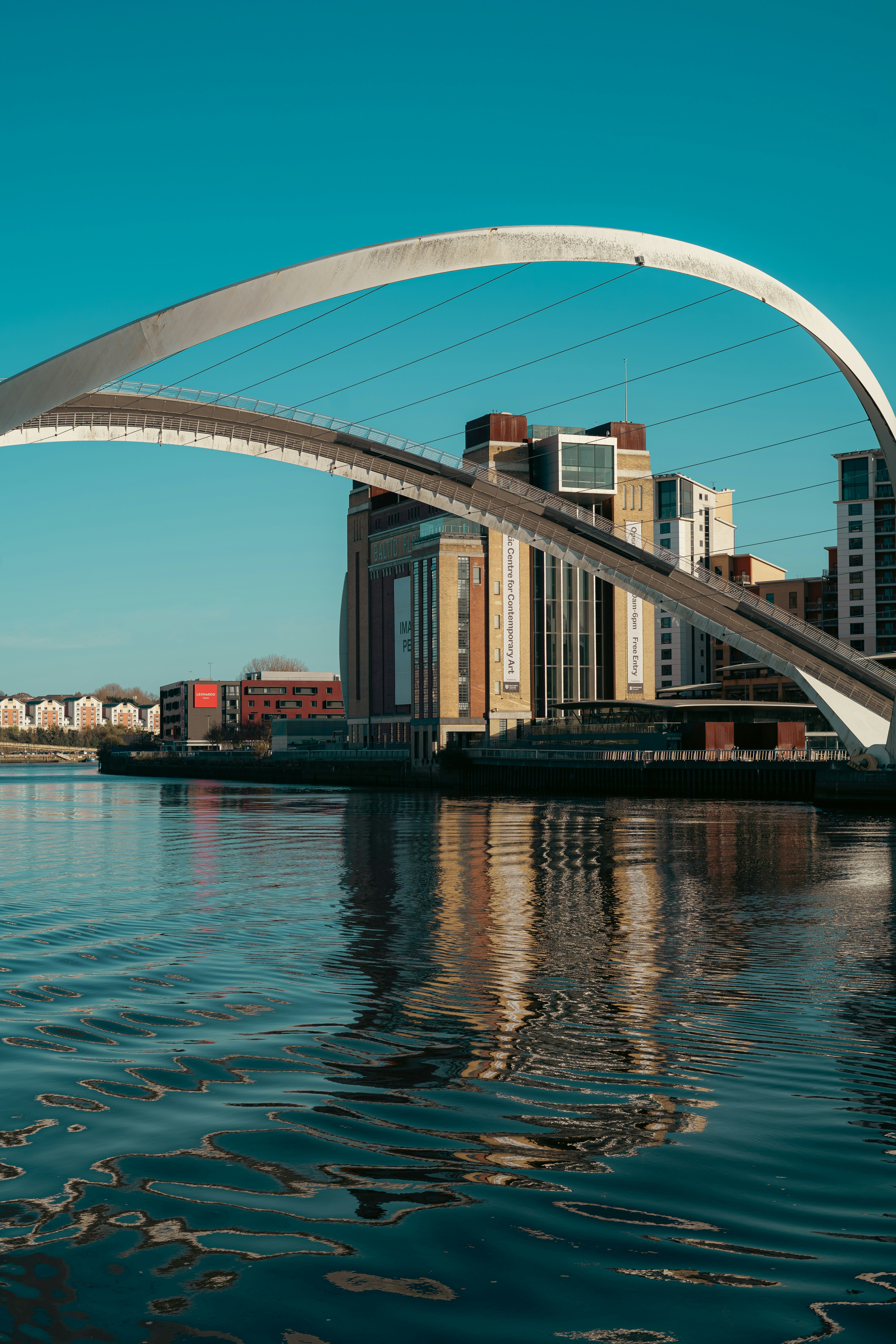 A bridge over a body of water with buildings in the background