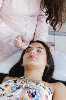 A woman getting her hair done by a hair stylist