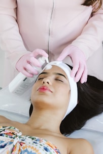 A woman getting a facial peel from a woman in a salon
