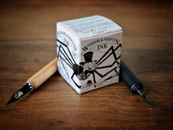 A pen sitting on top of a wooden table next to a box