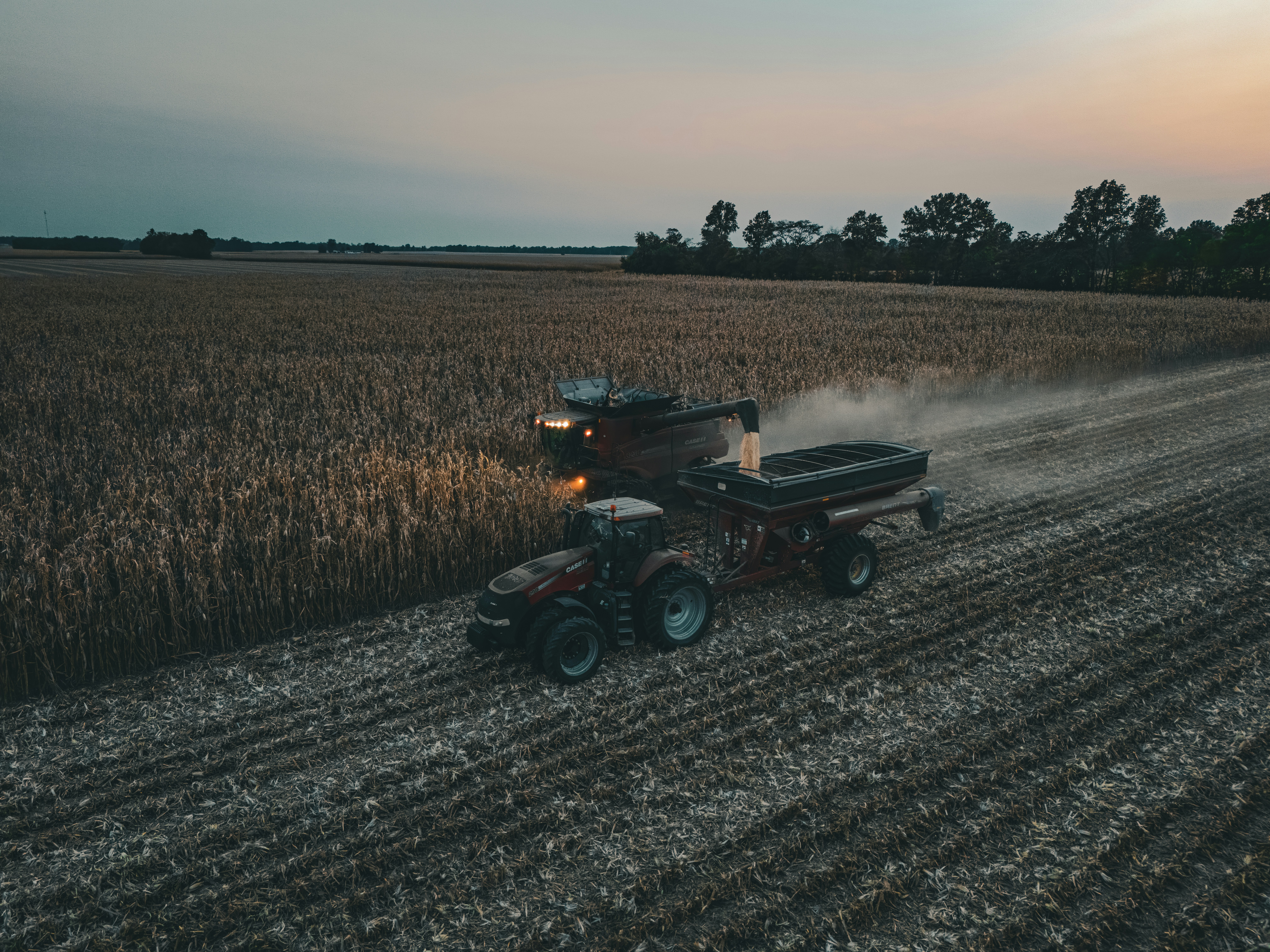 A tractor is driving down a dirt road