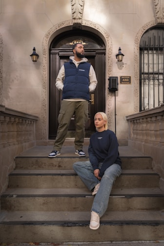 A man and a woman sitting on the steps of a building