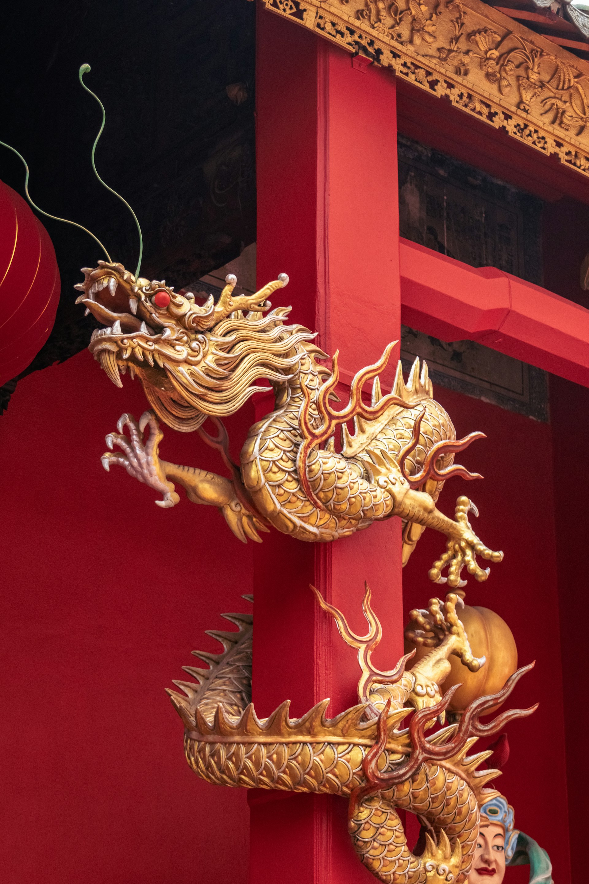 A tall red building with two golden dragon statues on it's side