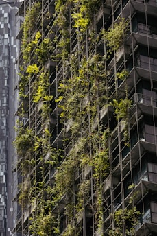 A very tall building with a bunch of plants growing on it