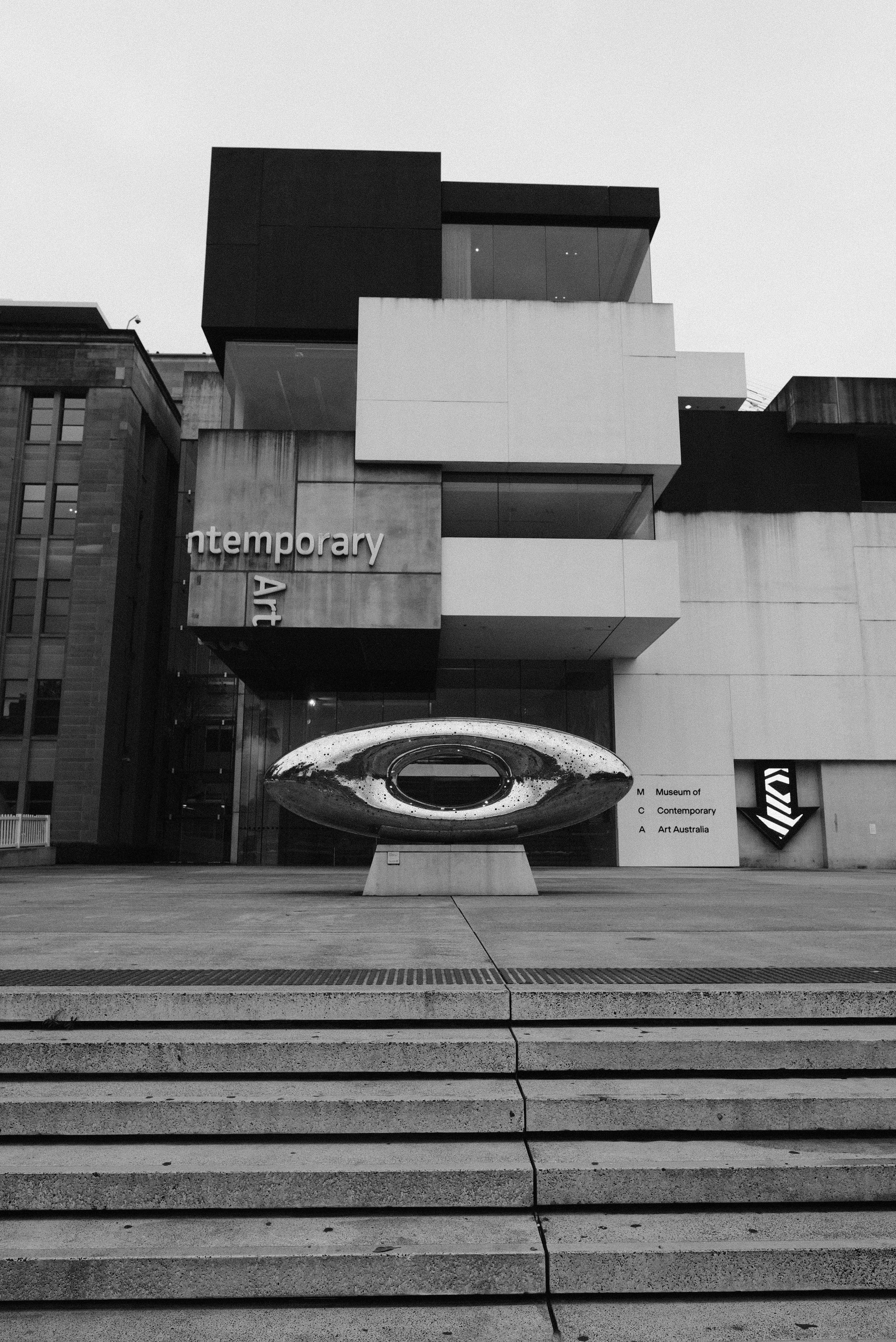 Une photo en noir et blanc d’un bâtiment avec des marches qui y mènent