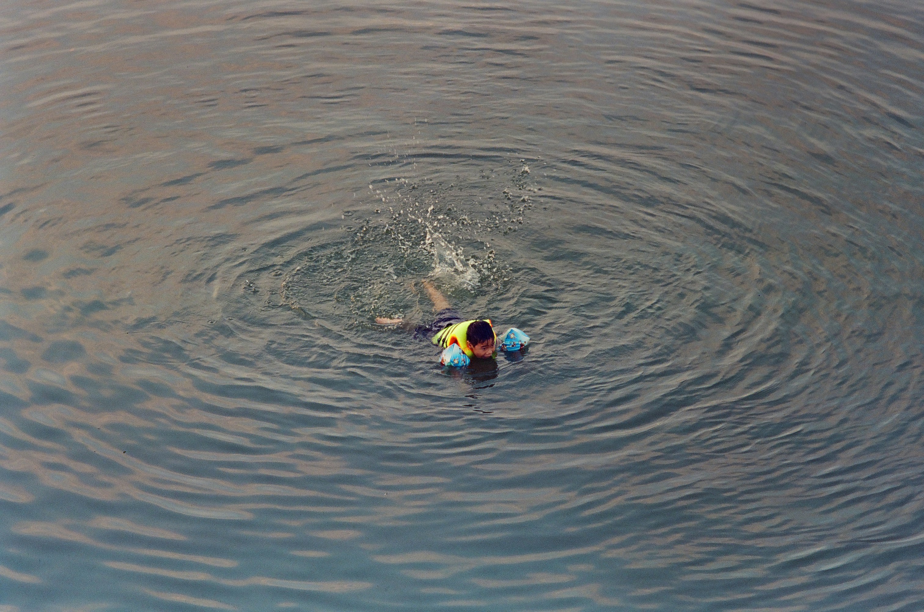 A couple of people swimming in a body of water