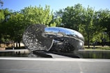 A large metal object sitting in the middle of a park