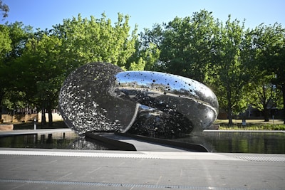 A large metal object sitting in the middle of a park