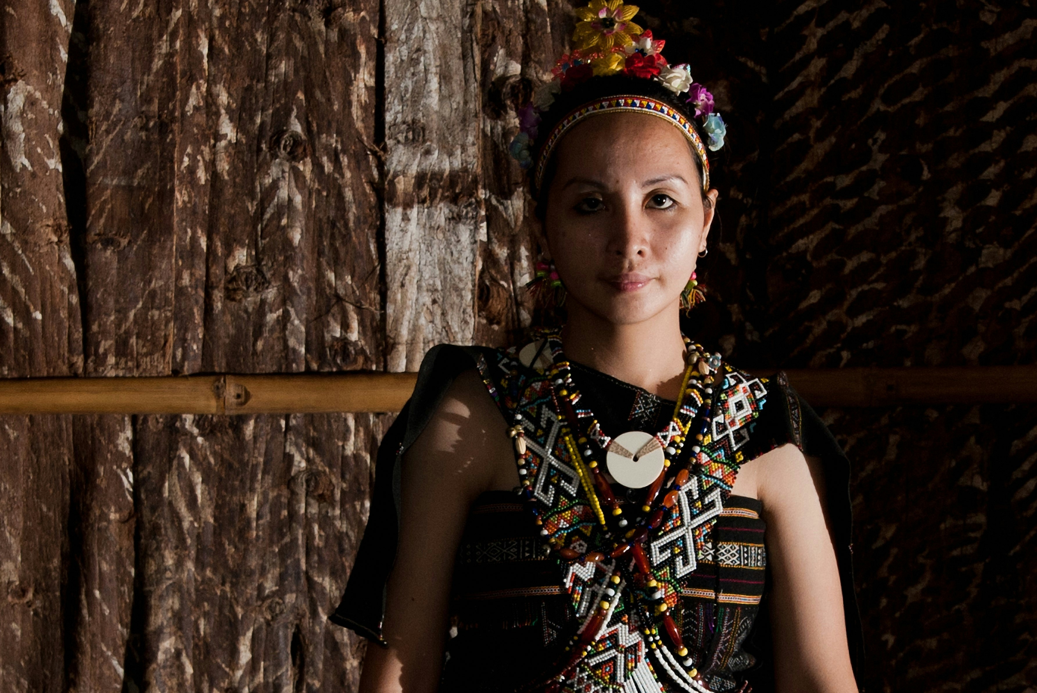 A woman in a dress standing in front of a wooden wall