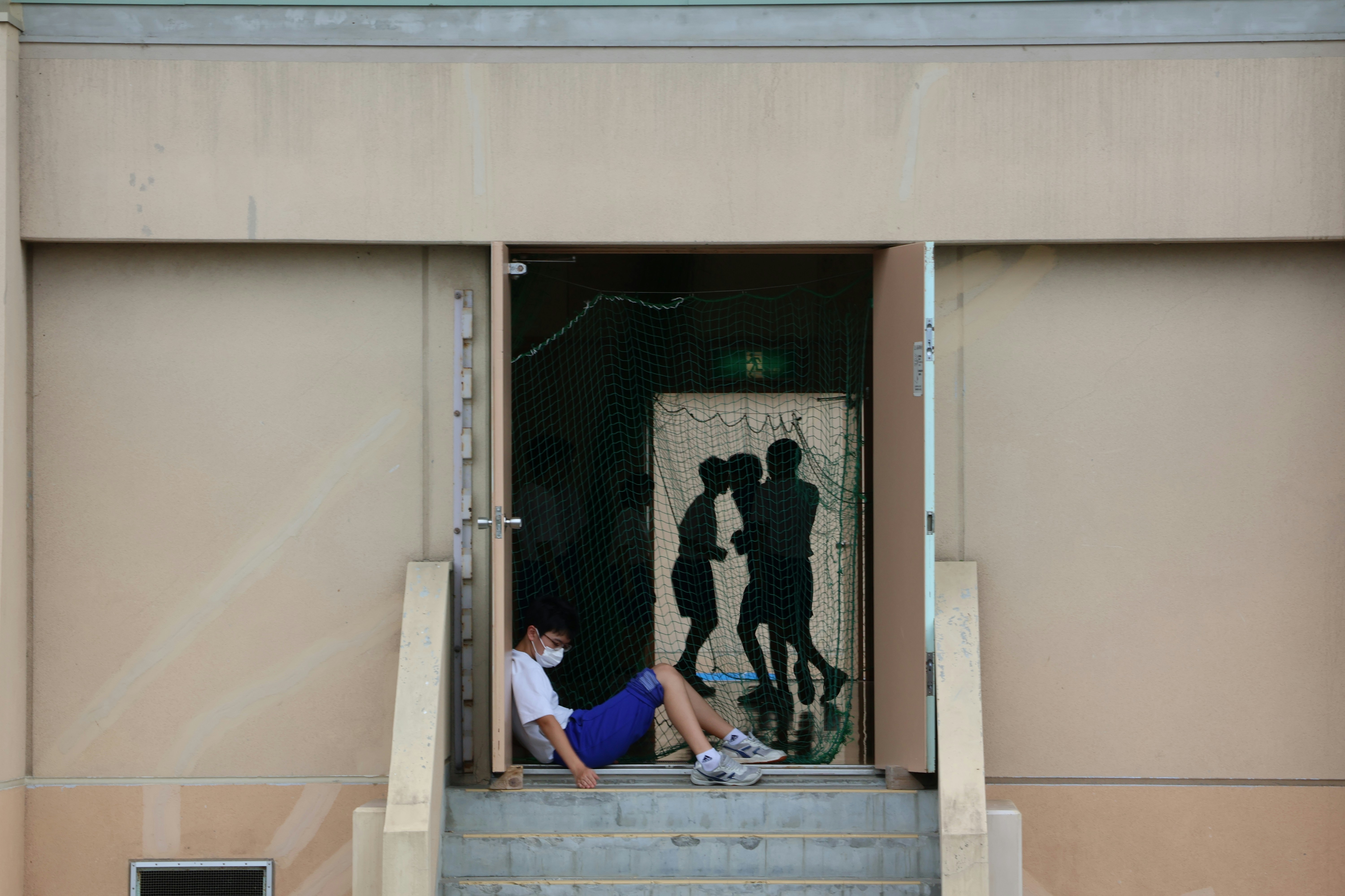 A couple of people sitting on the steps of a building