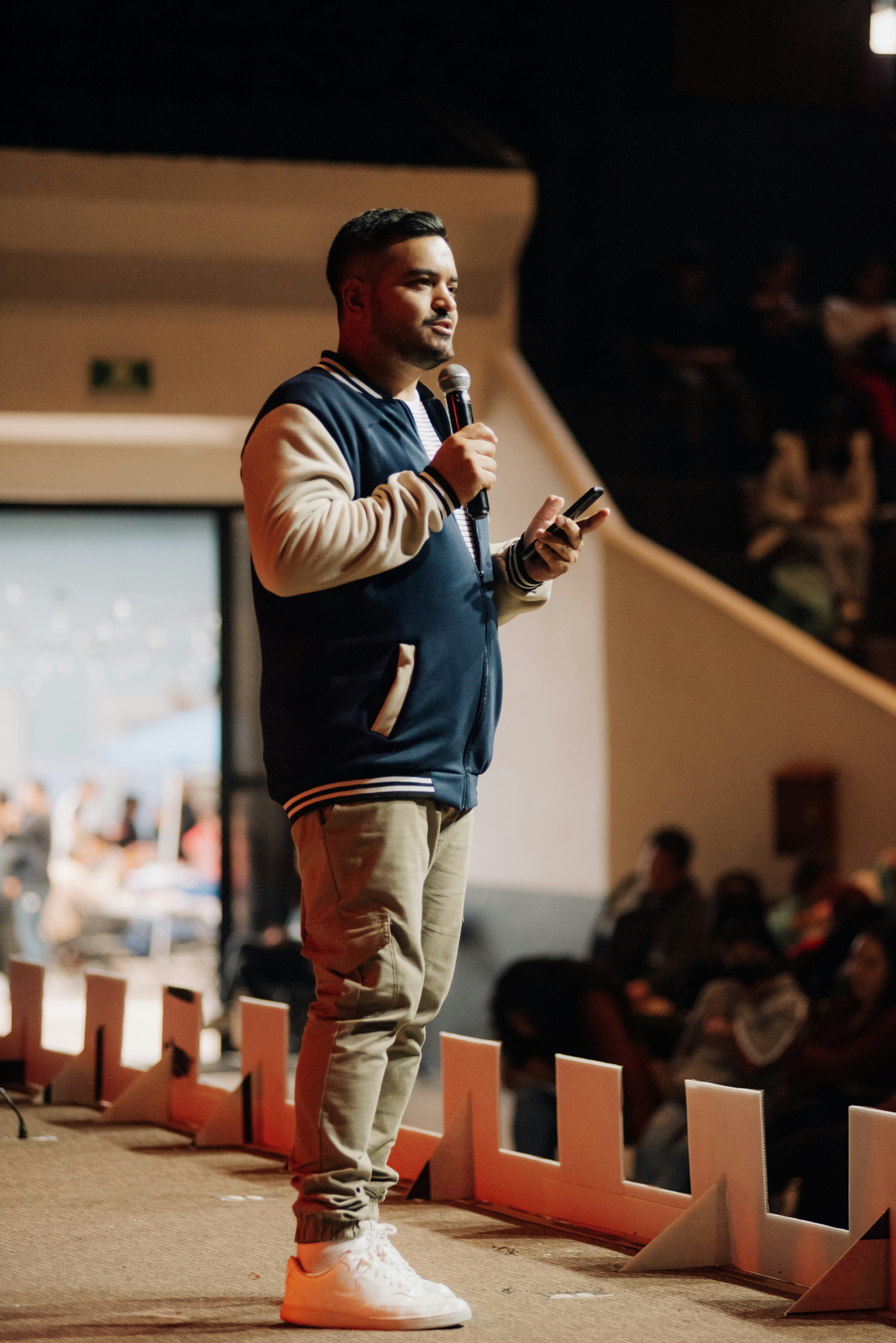 A man standing in front of a crowd holding a microphone