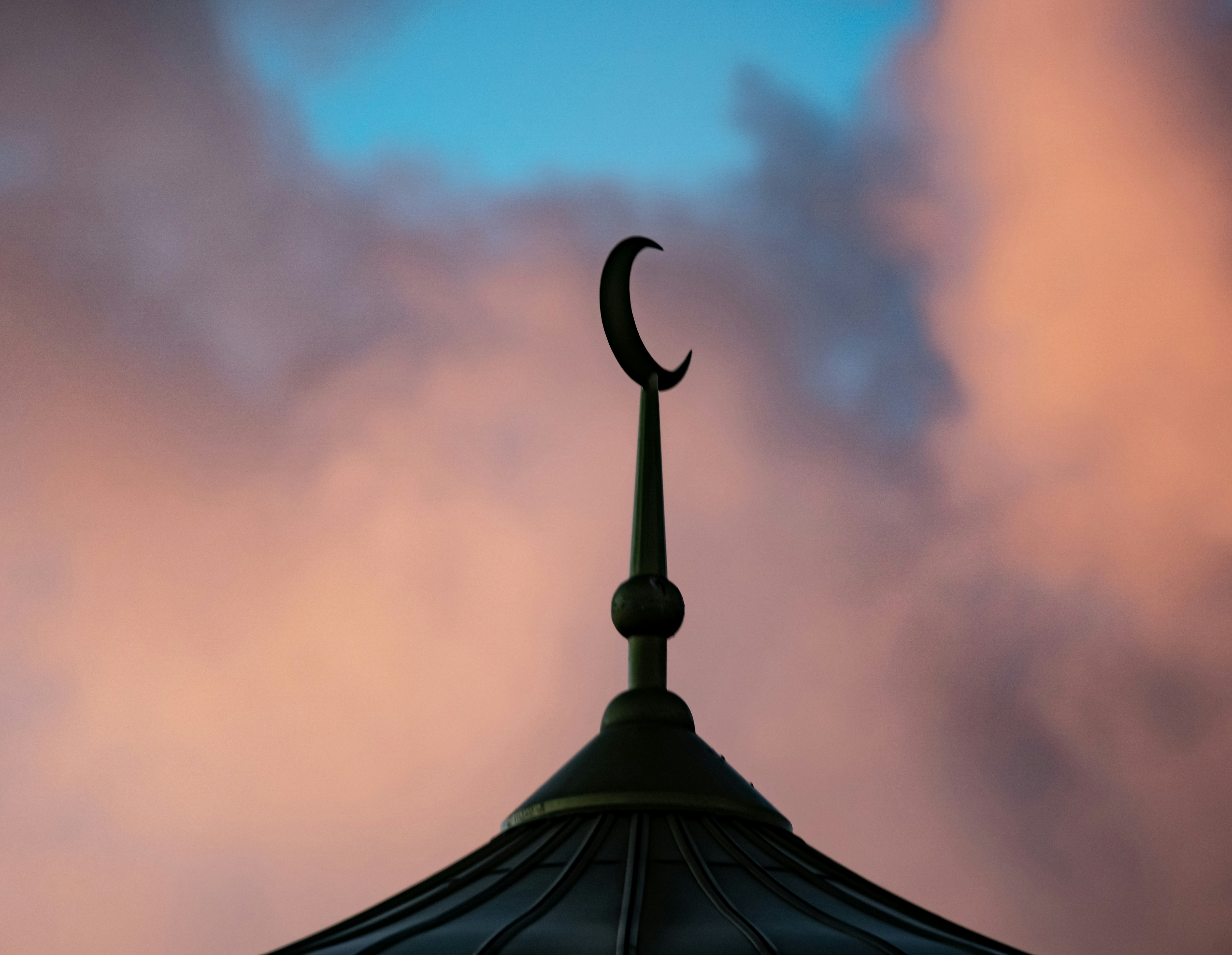 A clock tower with a crescent on top of it
