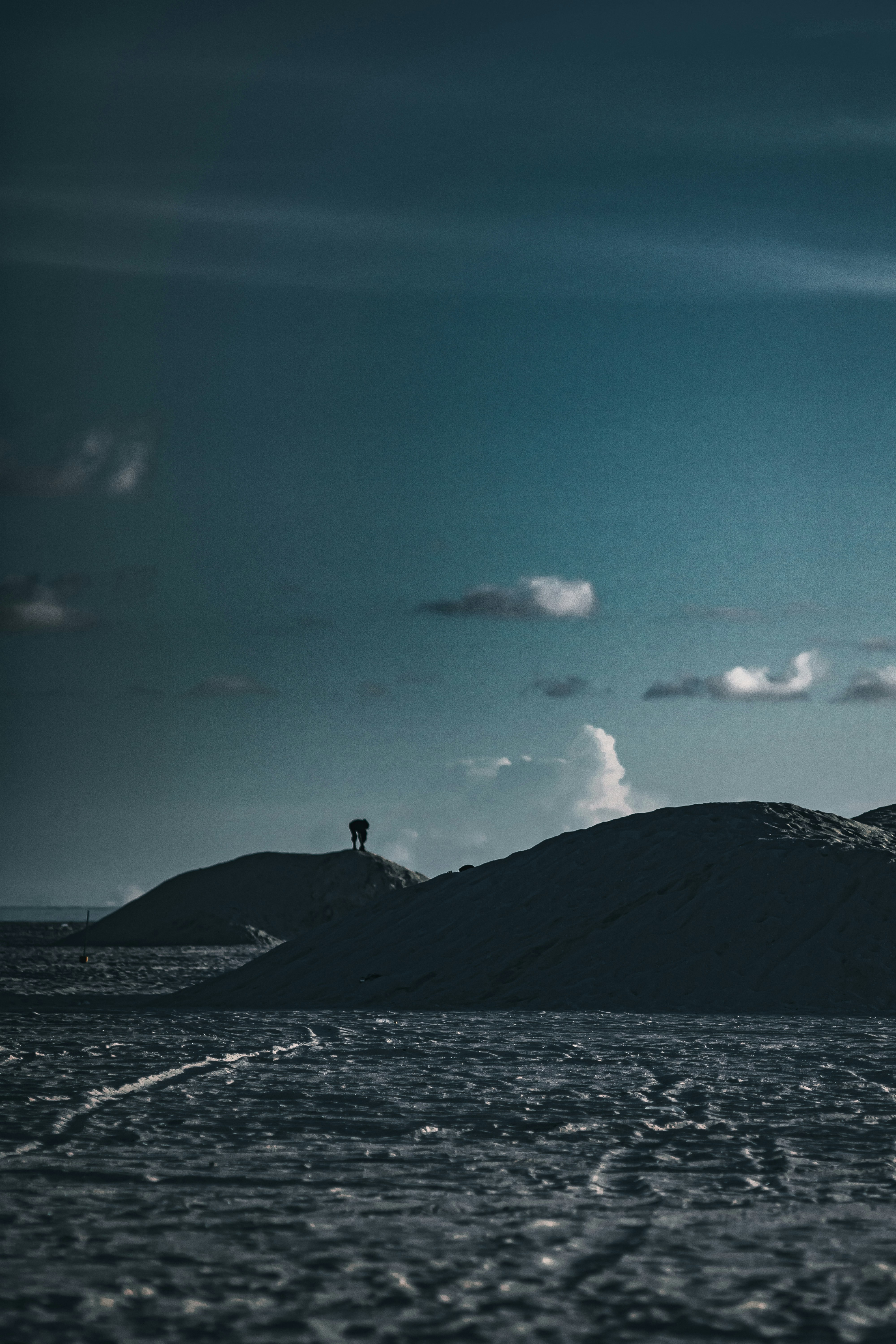 A lighthouse on a small island in the middle of the ocean
