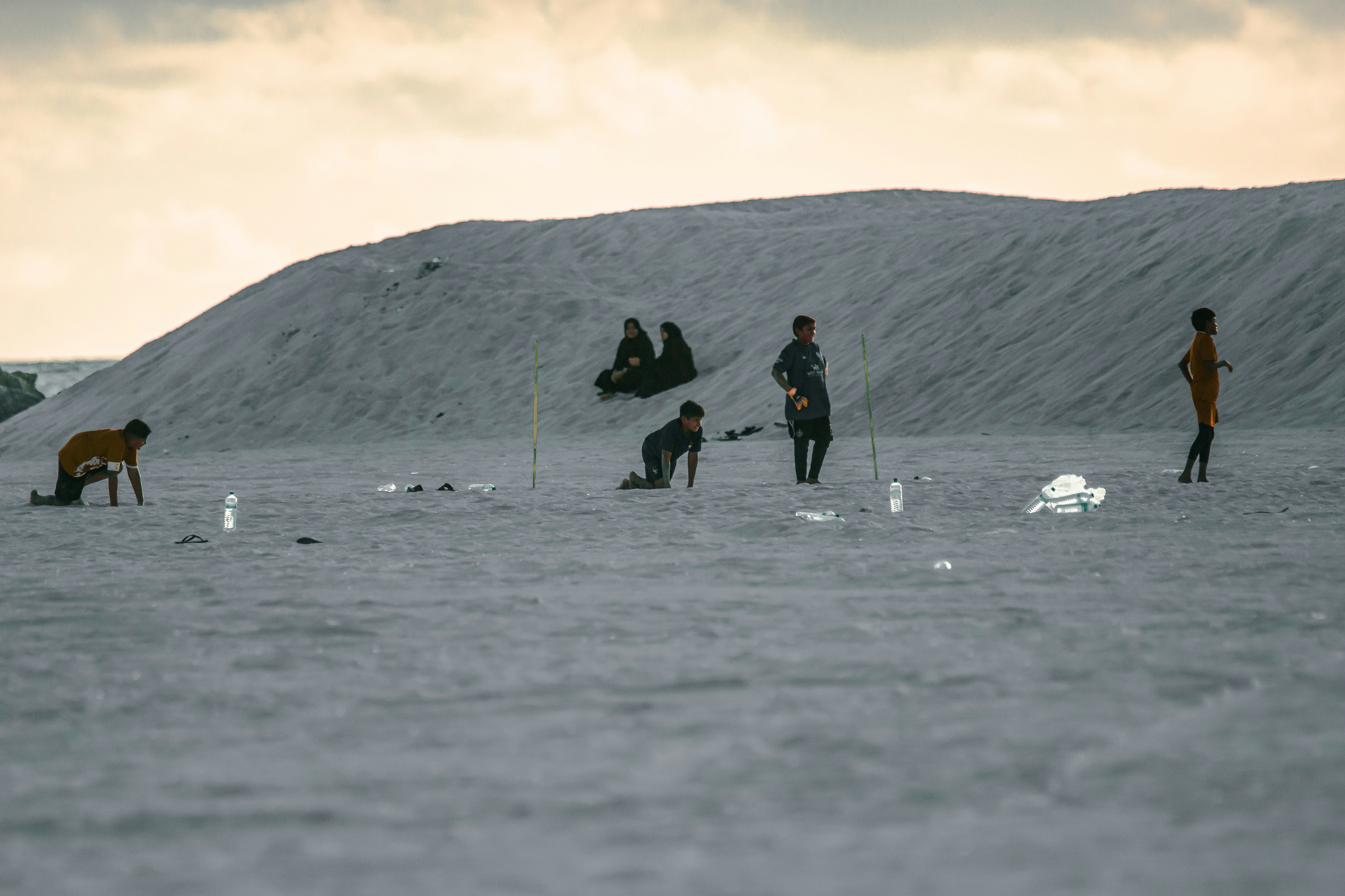 A group of people standing on top of a sandy beach