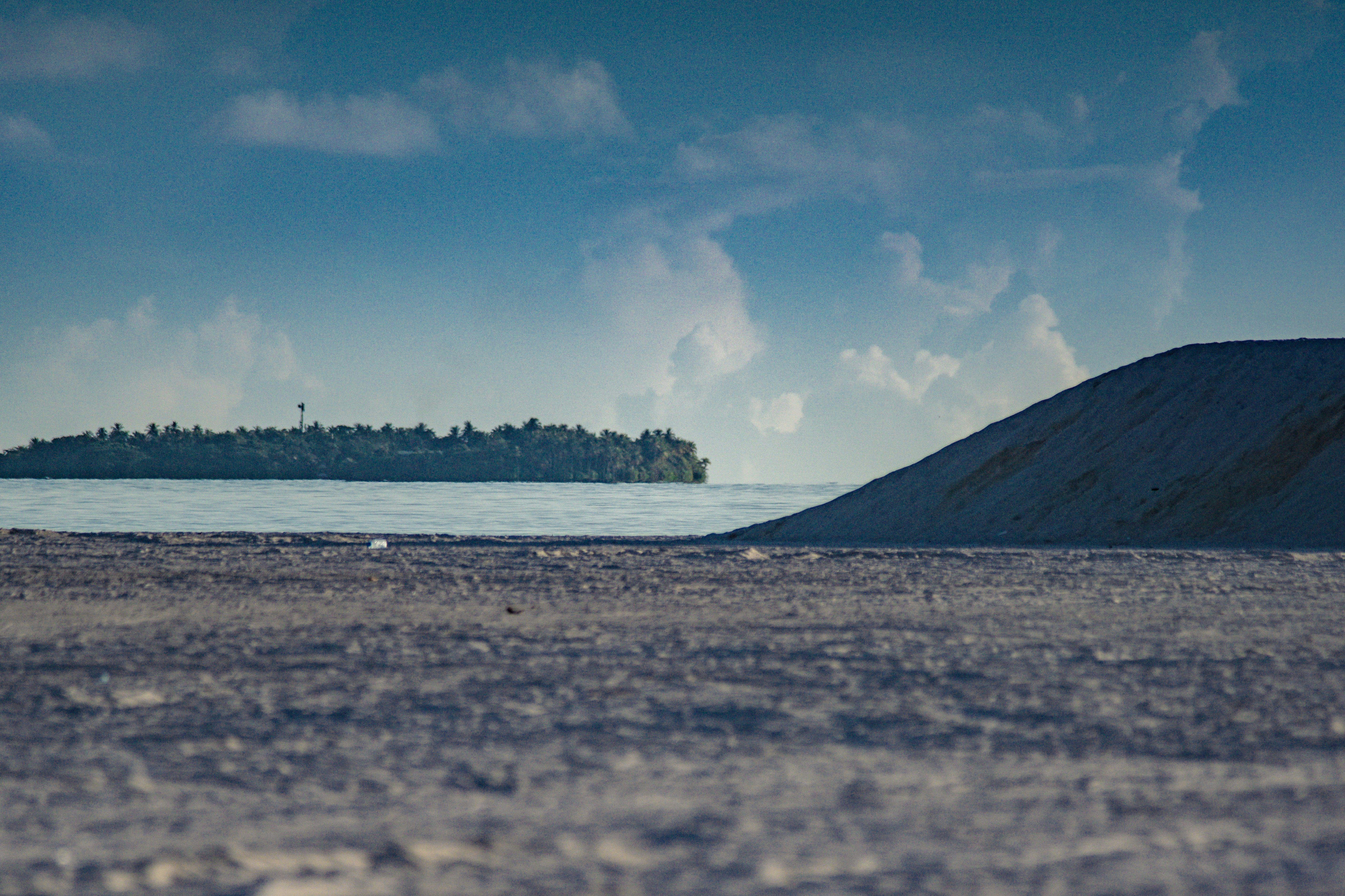 A small island sits in the distance of a large body of water