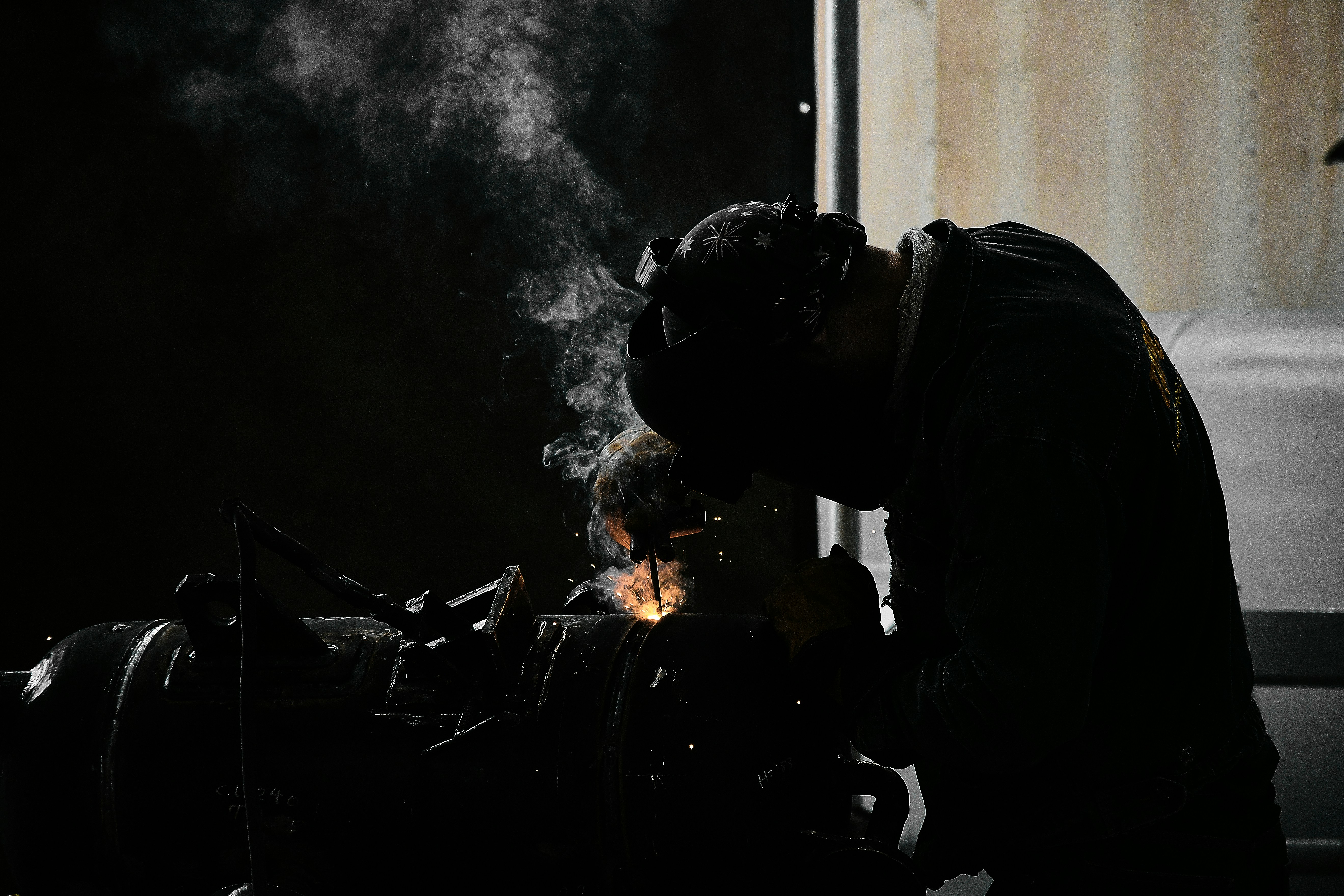 Un hombre trabajando en una motocicleta en una habitación oscura