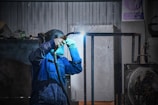 A man in a blue jacket holding a flashlight