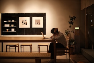 A woman sitting at a table using a laptop computer