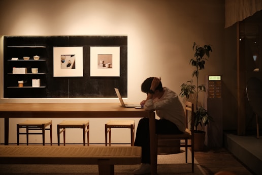 A woman sitting at a table using a laptop computer