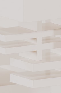 A white wall with a clock on the top of it