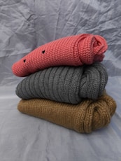 A stack of three knitted blankets sitting on top of each other