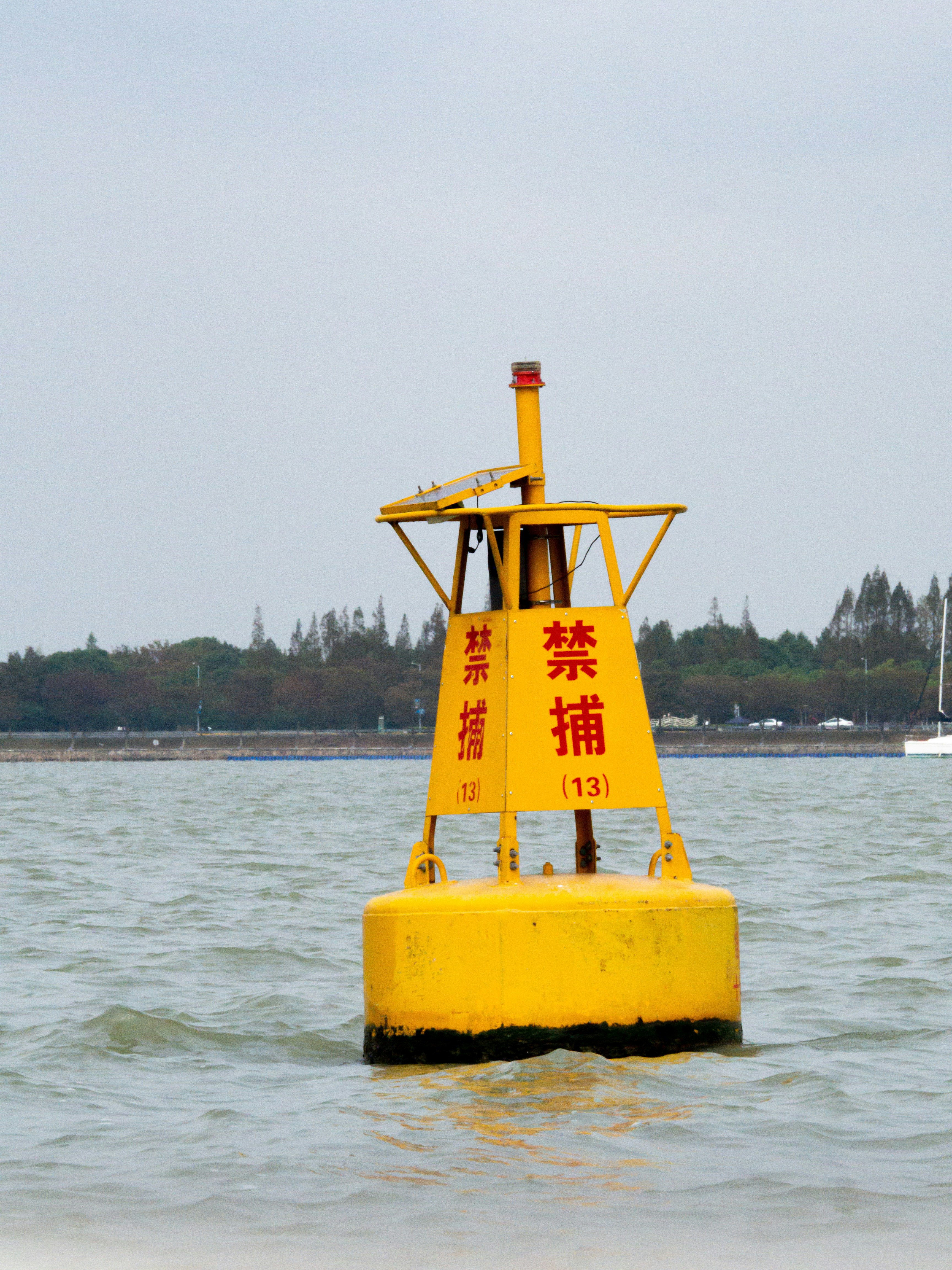 A yellow buoy sitting in the middle of a body of water