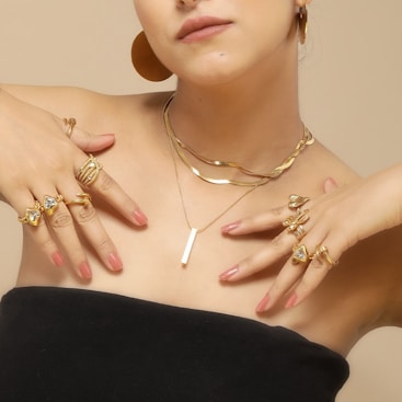 A woman in a black dress with rings and rings on her chest