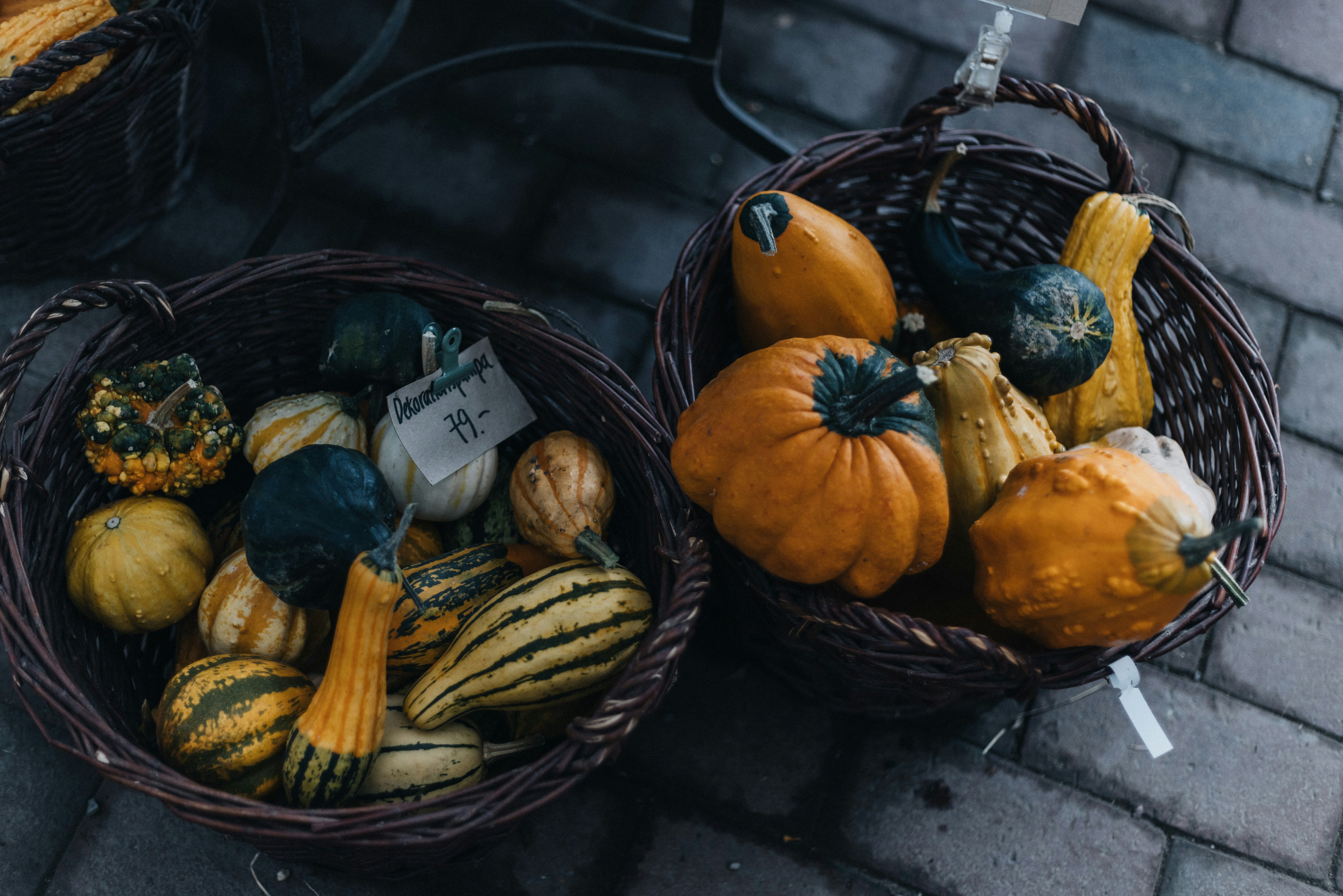 A couple of baskets filled with lots of different types of pumpkins