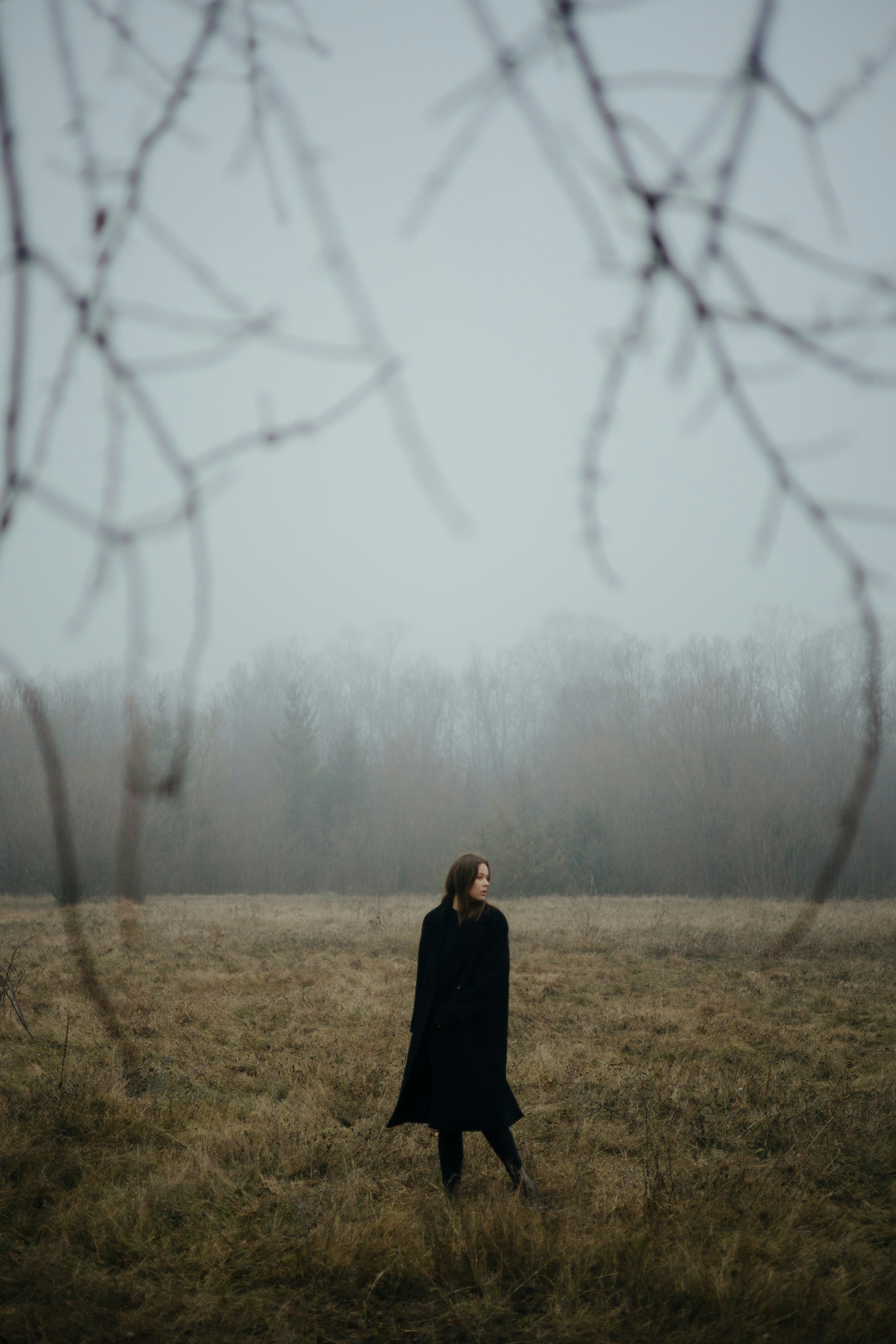 A woman standing in a field in the fog