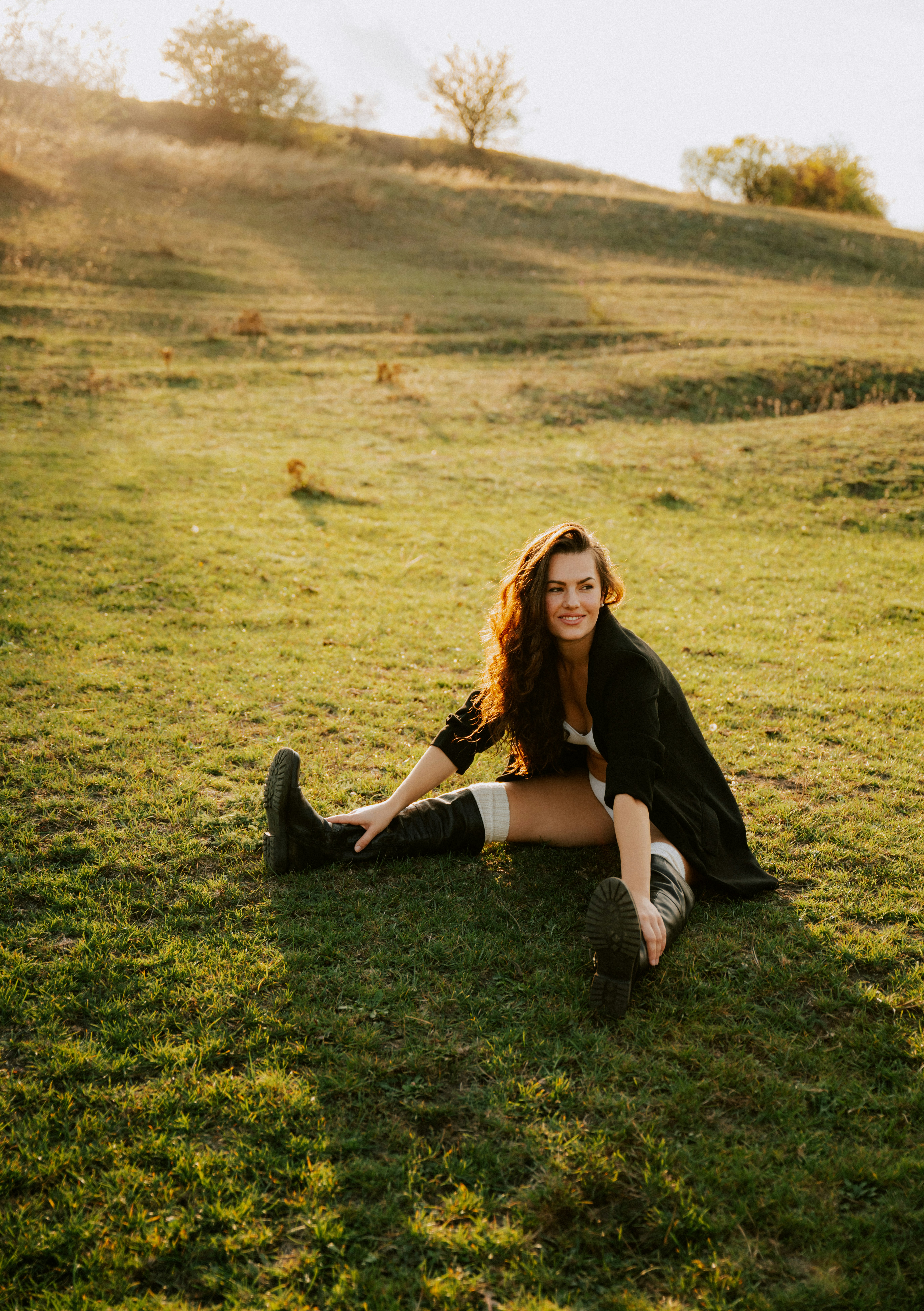 A woman sitting on the ground in a field