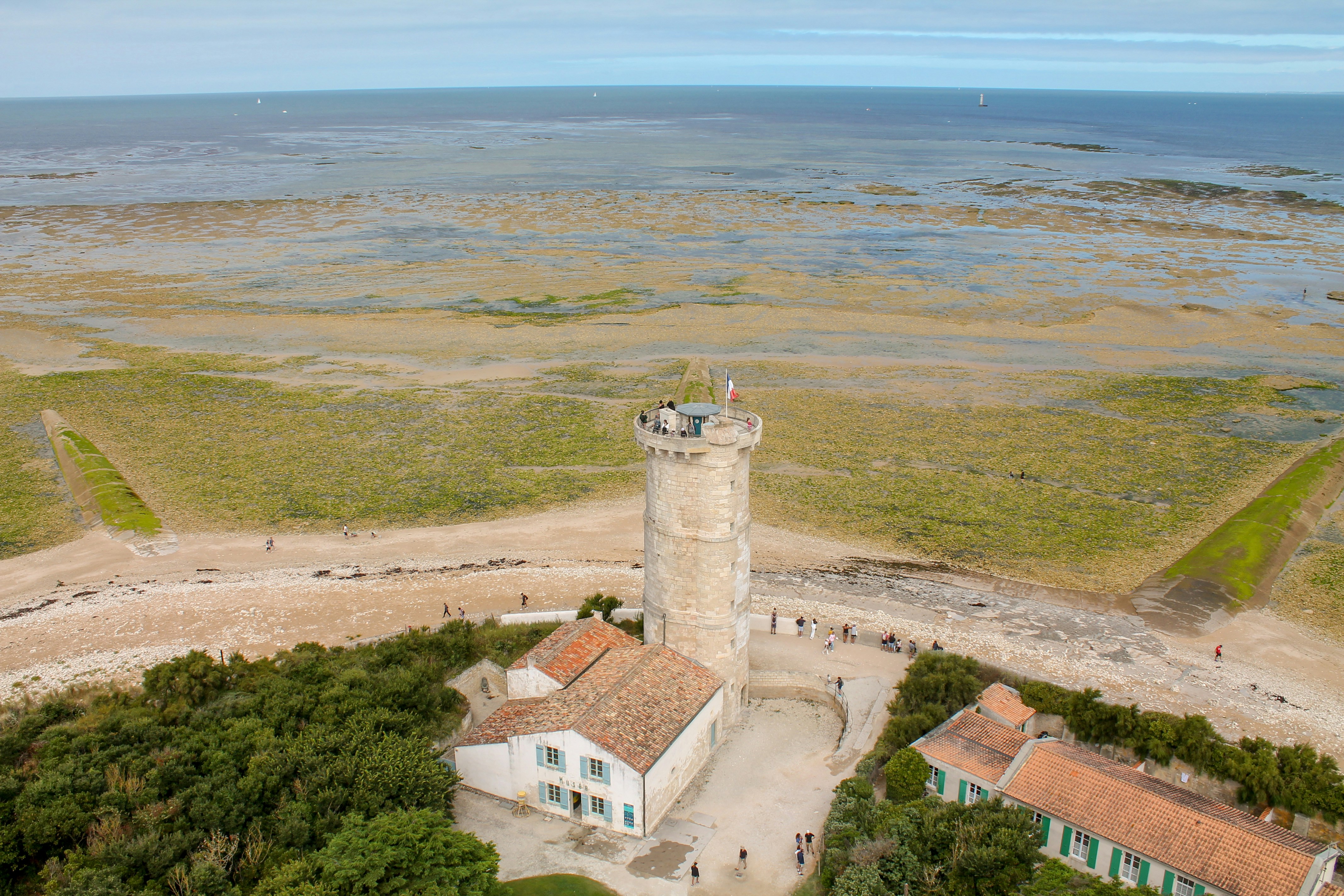 An aerial view of a lighthouse near the ocean