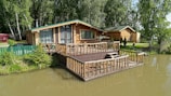 A house sitting on top of a river next to a forest