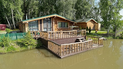 A house sitting on top of a river next to a forest