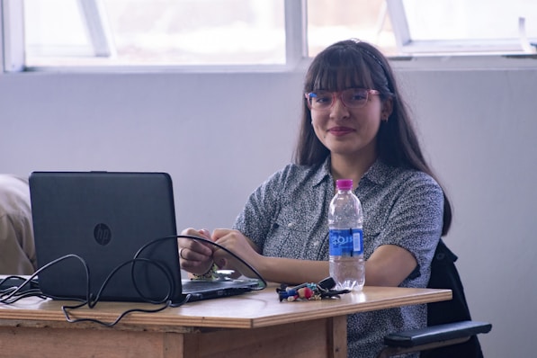 A woman sitting at a desk with a laptop computer