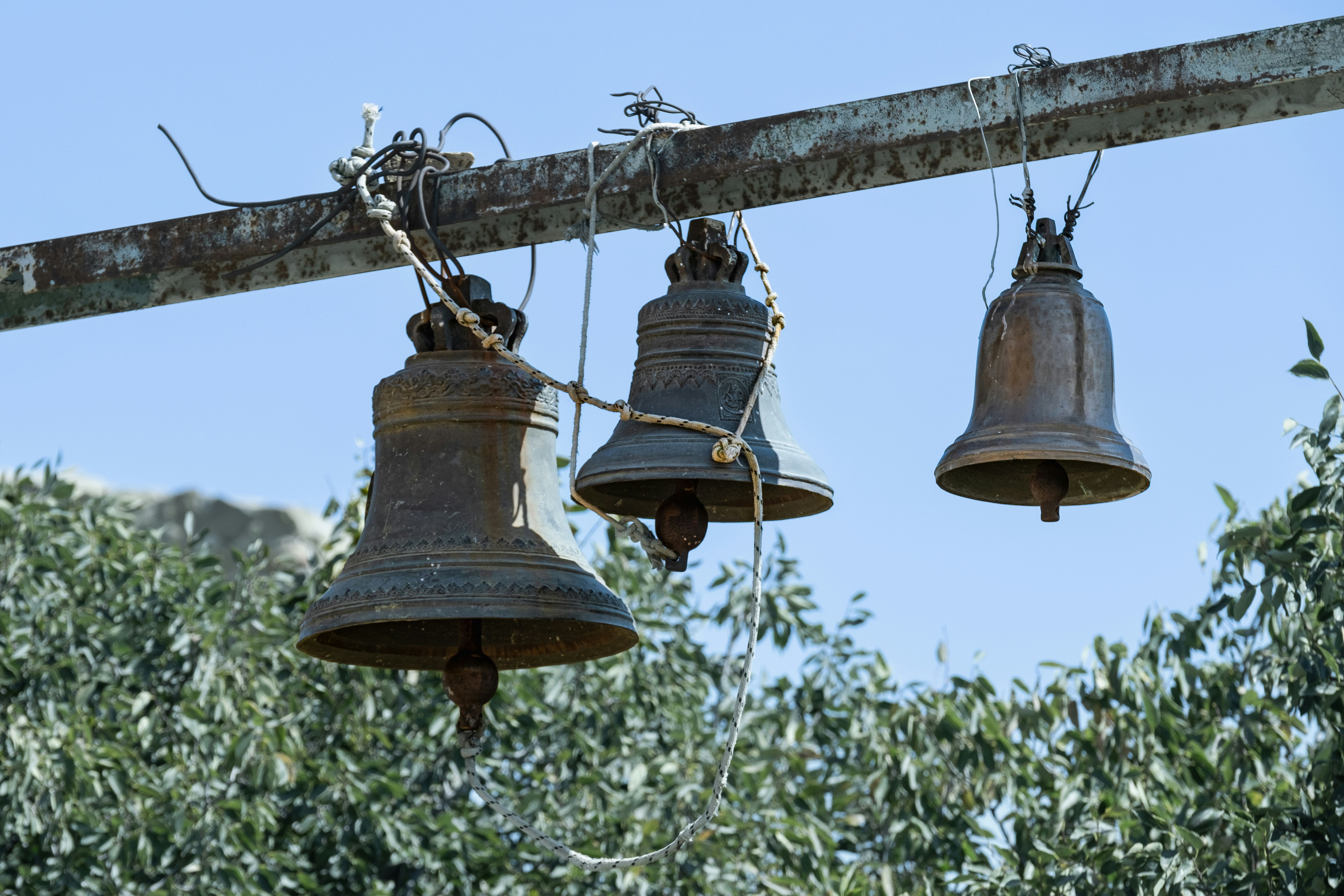 A group of bells hanging from a metal pole