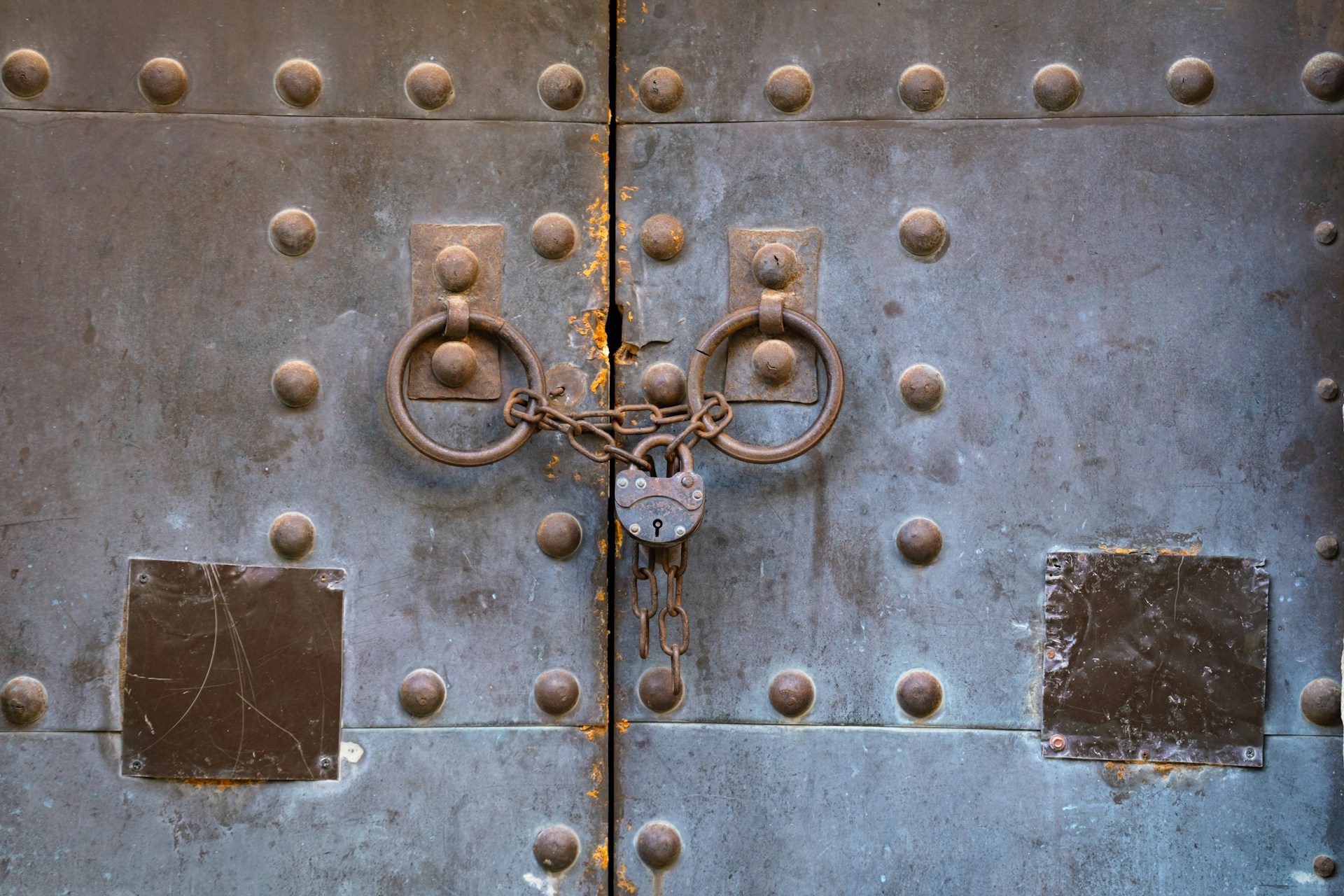 A close up of a metal door with rivets