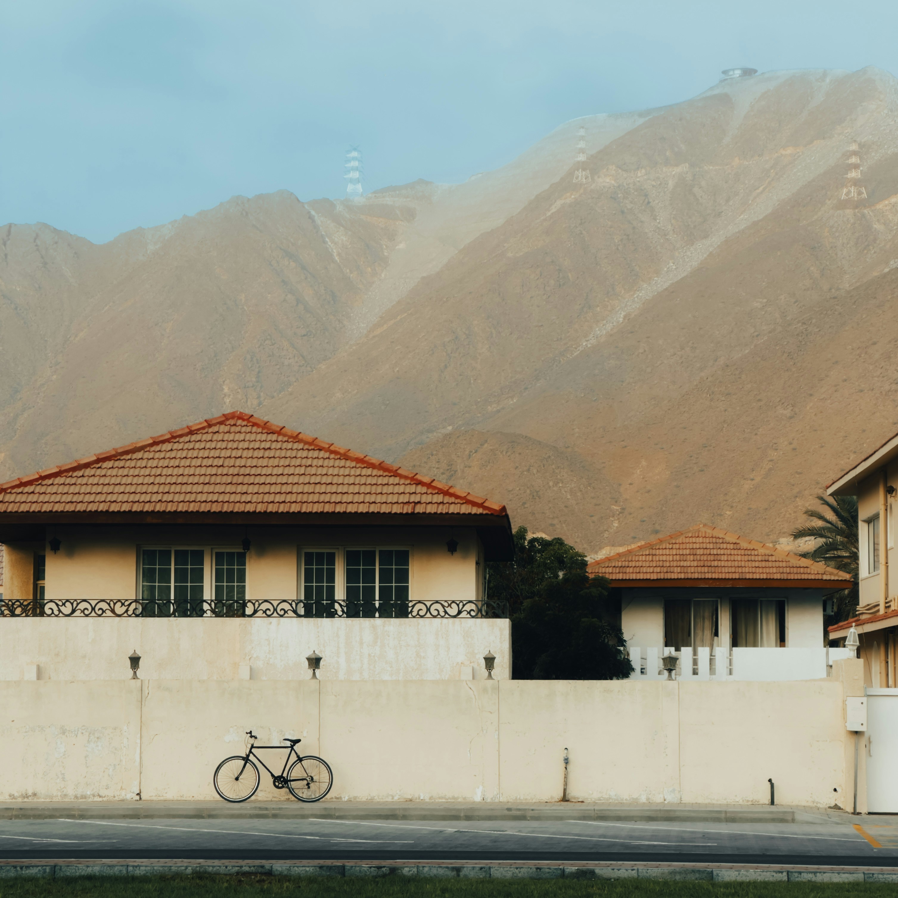 A bike parked in front of a house with mountains in the background