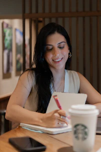 Mujer joven planificando su semana en su agenda con una taza de café