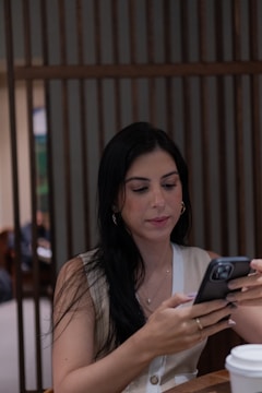 A woman sitting at a table using a cell phone