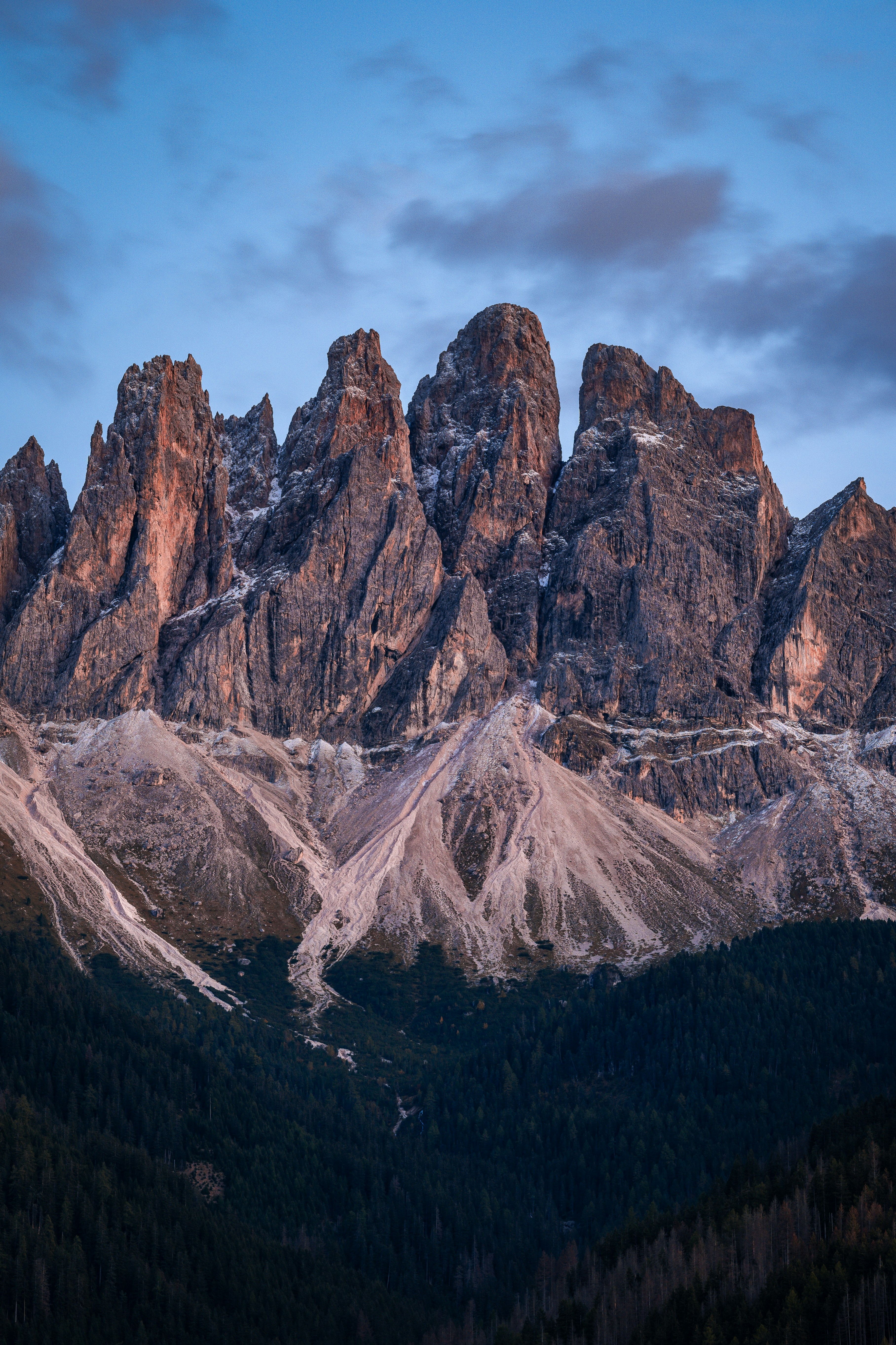 A mountain range covered in snow at sunset