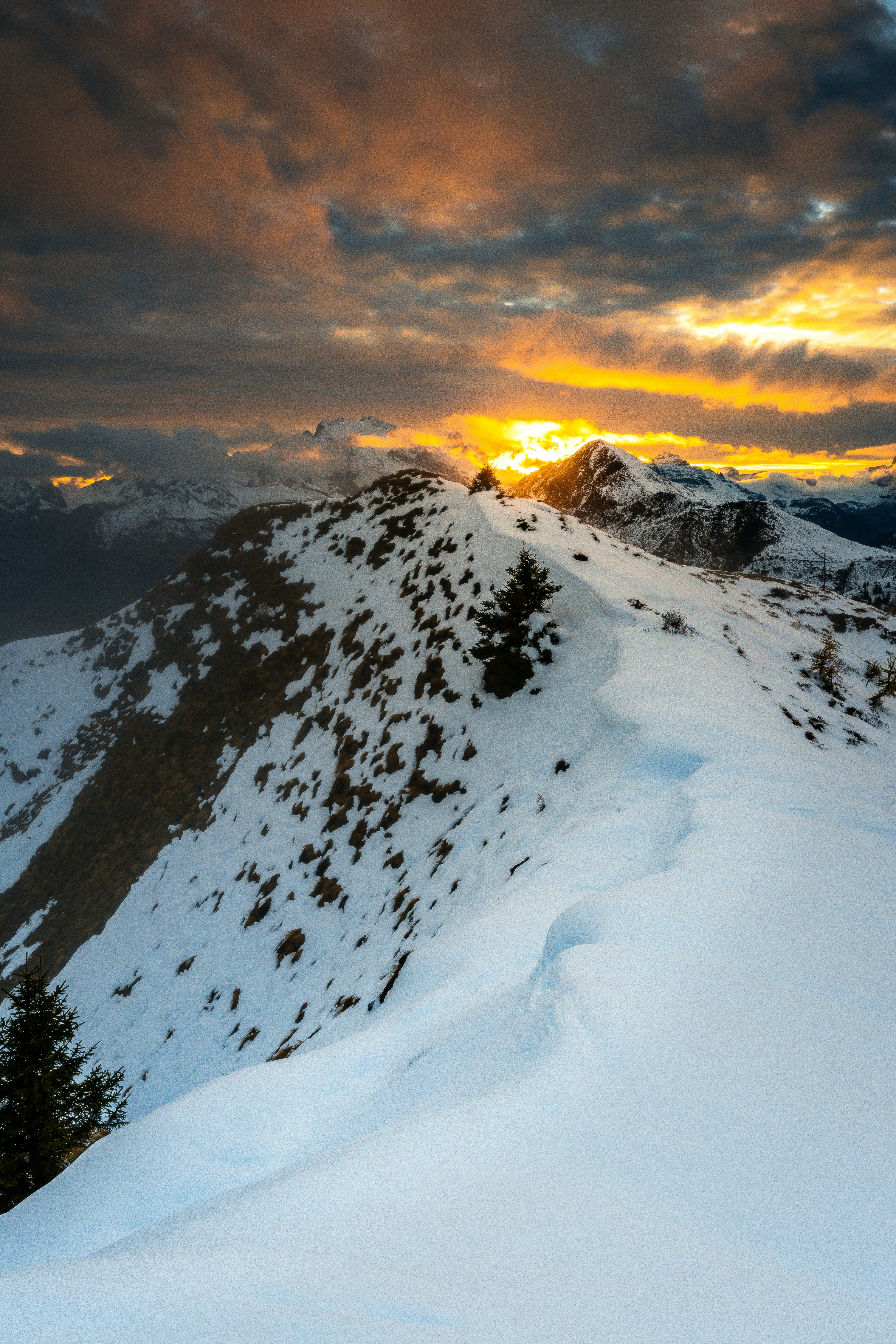 A snow covered mountain with a sunset in the background