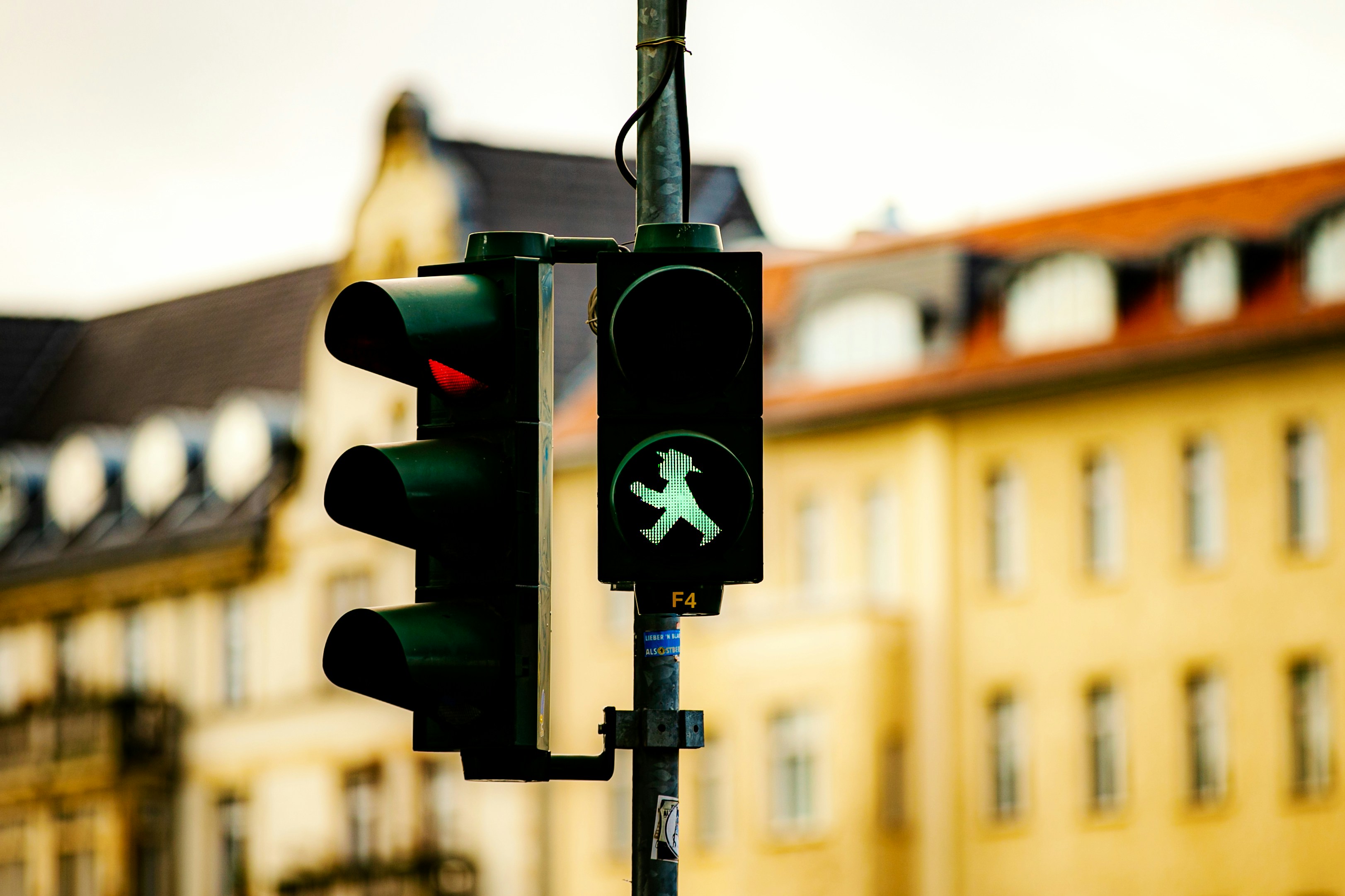 A traffic light with a green pedestrian sign on it