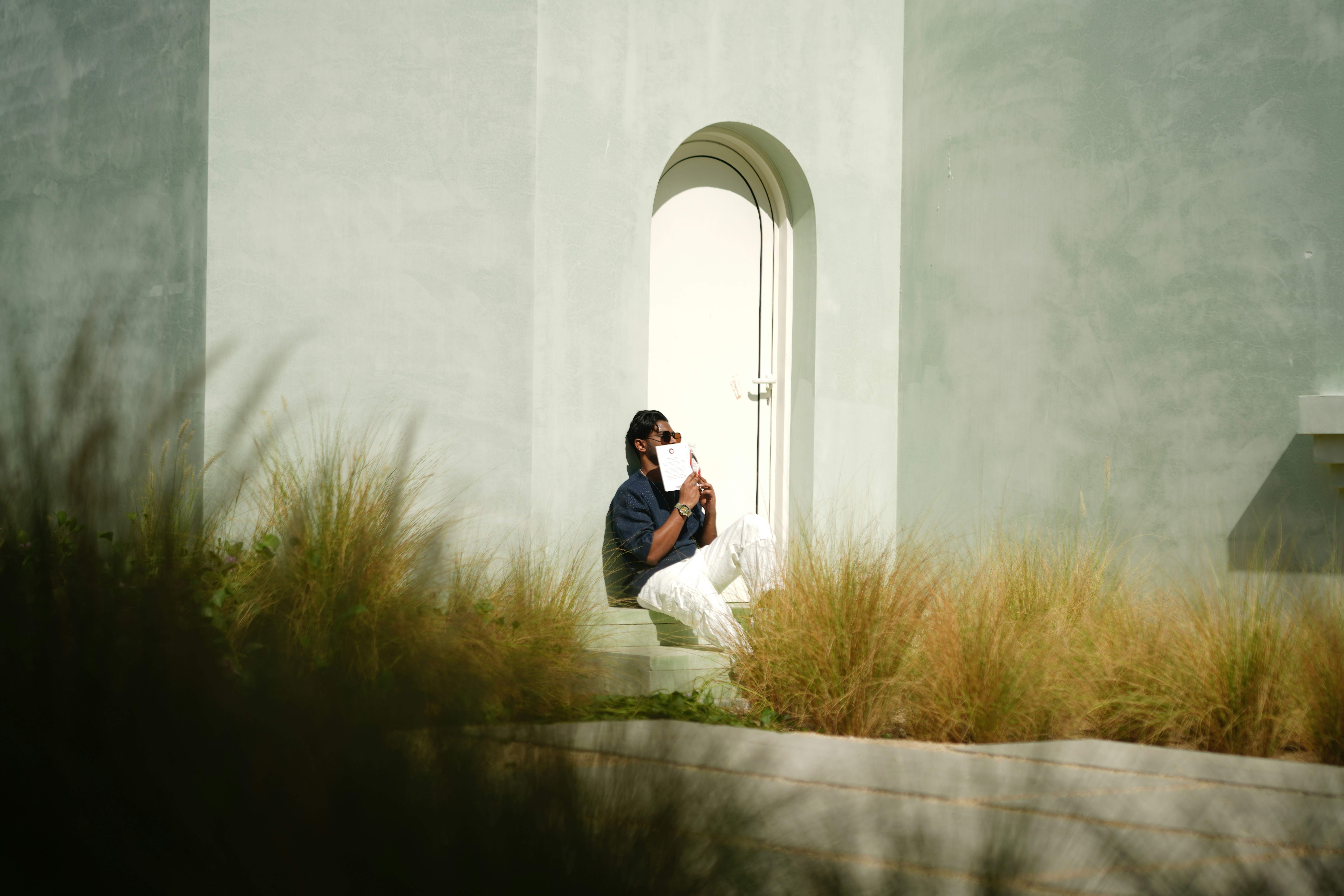 A person sitting on a step in front of a building