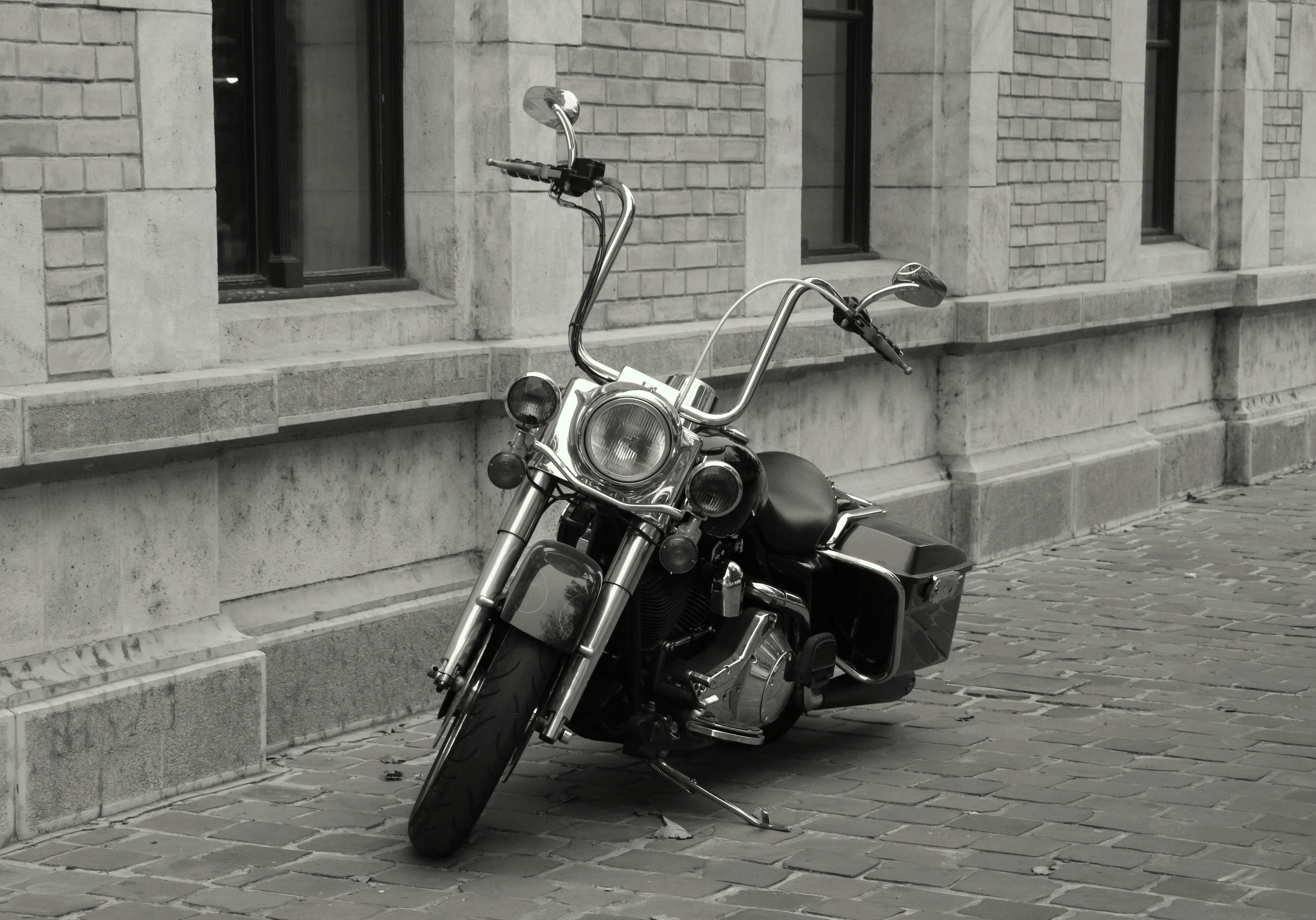 A black and white photo of a motorcycle parked in front of a building